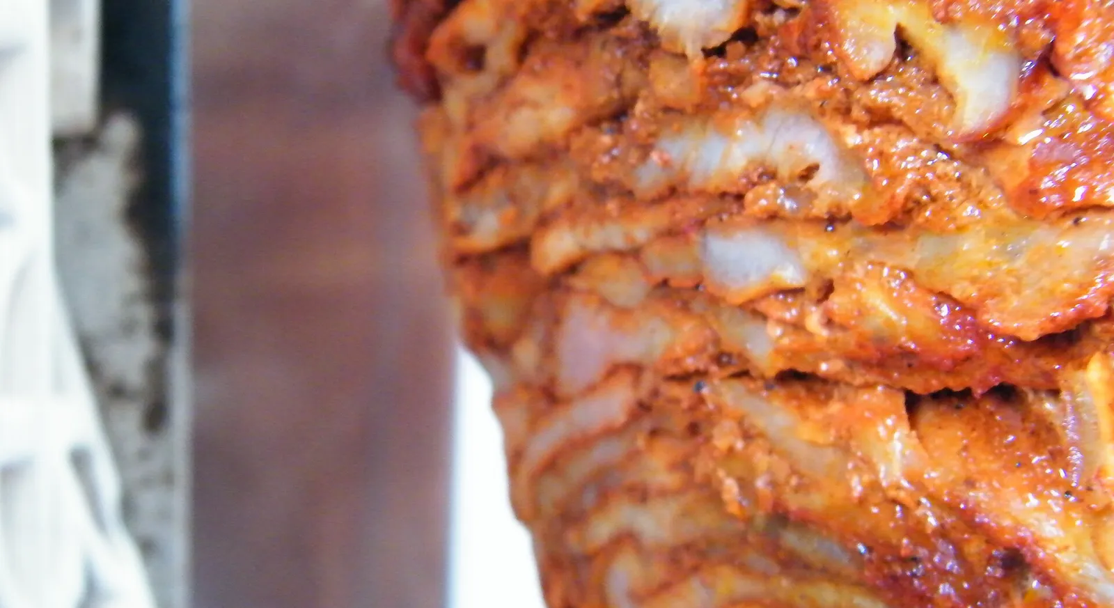 Marinated pork stacked on a vertical trompo spit for al pastor