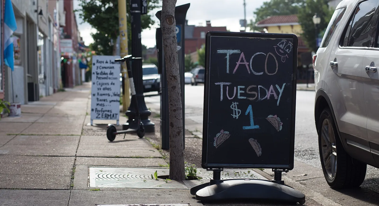 A sidewalk chalkboard sign advertising $1 Taco Tuesday in St. Louis